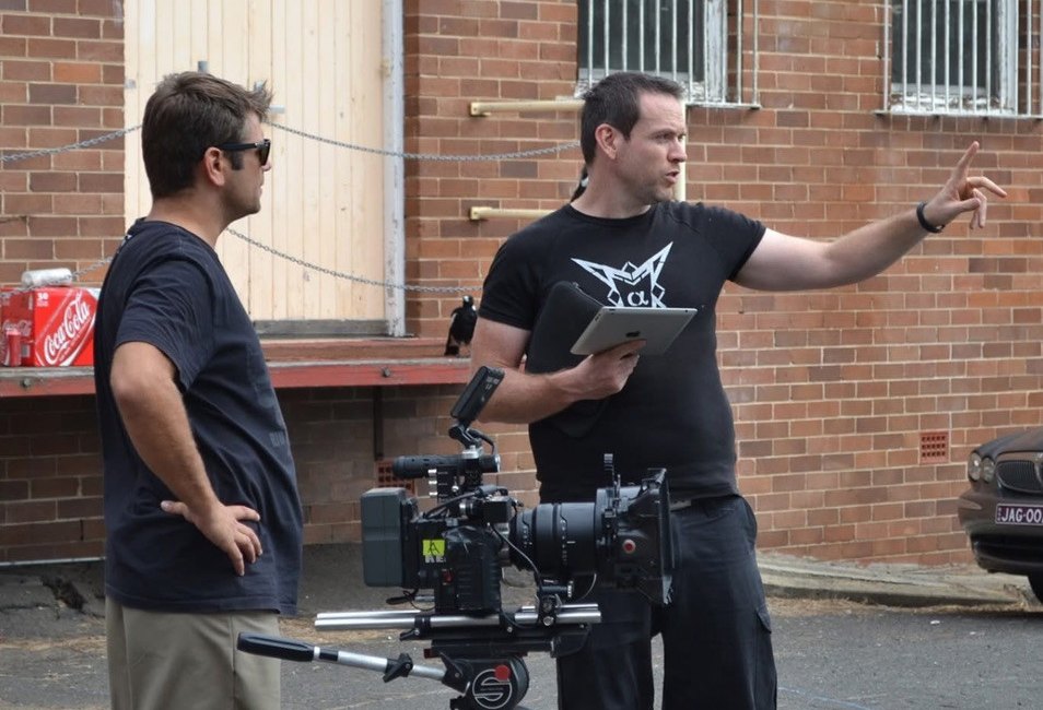 Timothy Boyle pointing on set while working beside a cinema camera