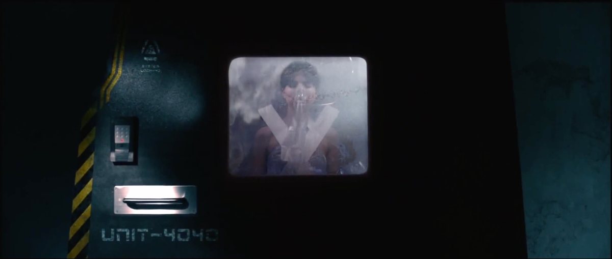 A woman seen through a window in a heavy door — Shadow Wars film still